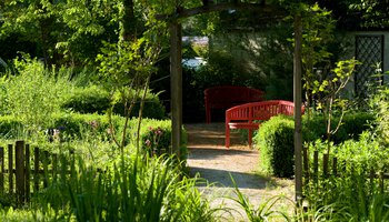 Rote Parkbank in grüner Gartenanlage | © © Photographien Thomas Klinger, www.atelierklinger.de